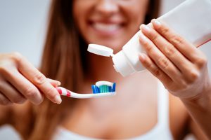 Close-up of a beautiful young woman brushing teeth. Selective focus.