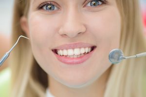 Close-up of female with open mouth during oral checkup at the dentist.Dentist