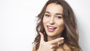 Portrait of a young smiling woman with beautiful white teeth. Gi